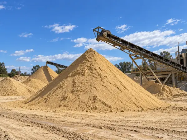 Pilas de arena de construcción en un depósito